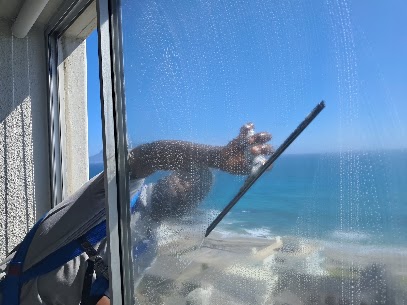 Team member cleaning a window in Hout Bay Cape Town